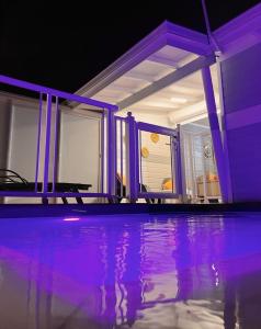 ein Haus mit einem Pool mit lilafarbener Beleuchtung in der Unterkunft Villa MauCa in Pointe-Noire