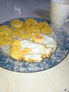 a plate with eggs and chips on a table at Alojamiento Hermanos Zambrano 204 in Cabra