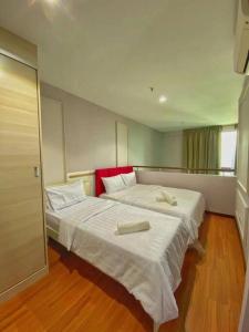 ein Schlafzimmer mit 2 Betten und Handtüchern darauf in der Unterkunft I- City in Kuala Selangor
