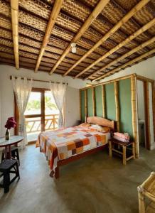 a bedroom with a bed and a large window at Pascana Casa Playa in Máncora