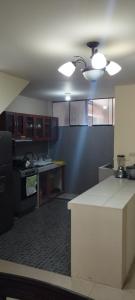 萬查科的住宿－Departamento Huanchaco，厨房配有棕色橱柜和白色台面