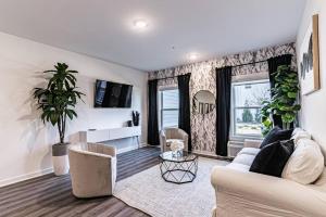 a living room with a white couch and a tv at Posh Living Condo 