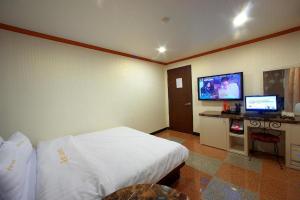 Habitación de hotel con cama y TV de pantalla plana. en New World Hotel Yongsan, en Seúl