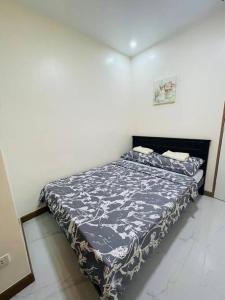 a bedroom with a bed with a blue and white comforter at A relaxing and accessible condominium unit. in Manila