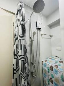 a bathroom with a shower and a shower curtain at A relaxing and accessible condominium unit. in Manila