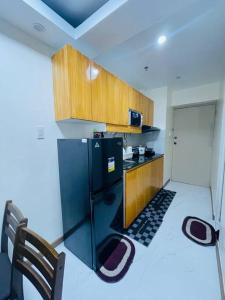 a kitchen with a black refrigerator and wooden cabinets at A relaxing and accessible condominium unit. in Manila