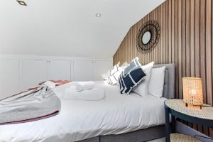 ein Schlafzimmer mit einem großen weißen Bett mit Kissen in der Unterkunft Tranquil Terra - Cozy and Soothing Vibe in Hanwell