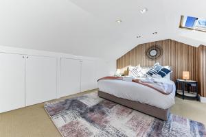 ein Schlafzimmer mit einem großen Bett und einem Teppich in der Unterkunft Tranquil Terra - Cozy and Soothing Vibe in Hanwell