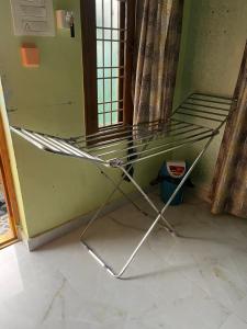 a metal chair in the corner of a room at SM Homestays 2 in Tirupati