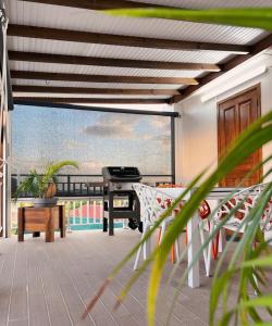 a balcony with a piano and a table and chairs at Villa MauCa in Pointe-Noire