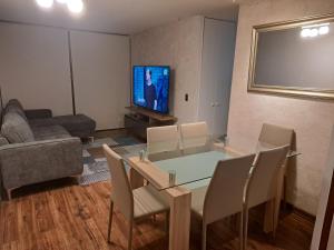 uma sala de estar com uma mesa de jantar e uma televisão de ecrã plano em Depto. Playa La Herradura Coquimbo em La Serena