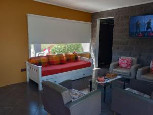 um quarto com uma cama e cadeiras e uma televisão em LAS LOMAS em Miramar