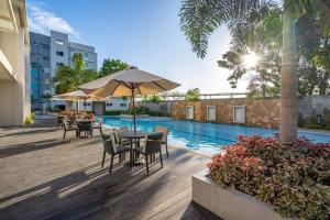 a patio with tables and chairs next to a pool at Standard Room at 8 Spatial by Forever-mc Condotel 8335 in Davao City