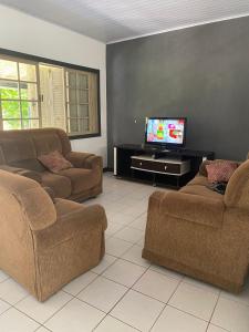 - un salon avec deux canapés et une télévision à écran plat dans l'établissement Paraíso tropical, à Cabo Frio