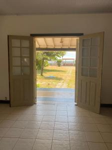 une porte ouverte donnant sur une chambre avec vue sur la cour. dans l'établissement Paraíso tropical, à Cabo Frio