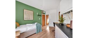 a bedroom with a bed and a green wall at Cozy and Lovely Studio - Close to everything! in London