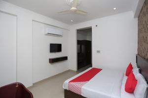 a bedroom with a bed and a tv on the wall at OYO Hotel Vandana in Alwar