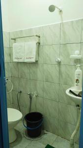 a bathroom with a sink and a toilet and towels at Santai HomeStay Sipitang in Sipitang