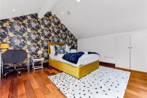 Comfortable 3 Bedroom Apartment in Greater London في Hanwell: غرفة نوم بسرير ومكتب وكرسي