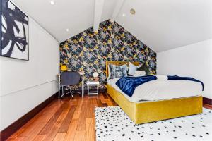 Comfortable 3 Bedroom Apartment in Greater London في Hanwell: غرفة نوم مع سرير مزدوج كبير مع اللوح الأمامي الأسود والذهبي