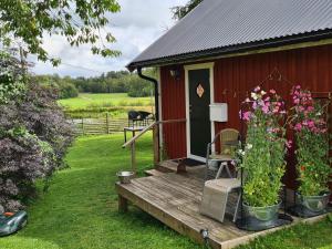una casa roja con un porche de madera con flores. en Holiday home HALMSTAD X, en Halmstad