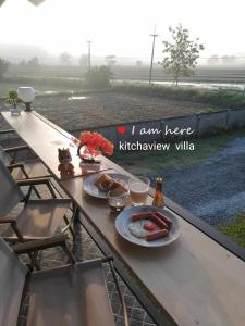 a table with two plates of food on a balcony at Kitchaview Villa in Chiang Rai