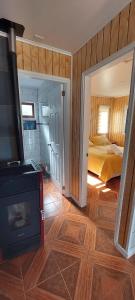 a room with a fireplace and a bedroom with a bed at cabaña los teros in Coihaique