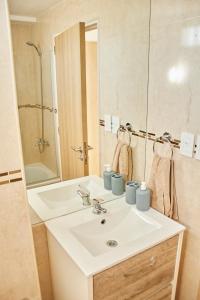 W łazience znajduje się biała umywalka i lustro. w obiekcie Moderno y Confortable en pleno centro de BsAs! Divino para 3 pax w BuenosAires