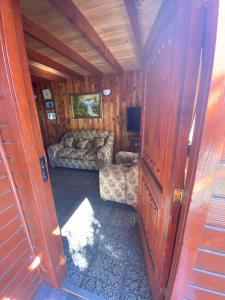 a living room with a couch and a television in a cabin at Casa Licanray in Licán Ray +12 photos