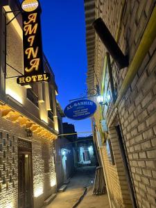 a building with a sign for a hotel on a street at Amina Hotel boutique in Bukhara