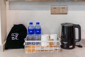 a basket with bottles of water and a kettle on a counter at Coco Apatement - Zhongshan Tianyi International Plaza Store in Zhongshan