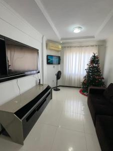 uma sala de estar com televisão e uma árvore de Natal em APARTAMENTO IMPERIAL IV (COMPLETO) em Castanhal