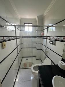 a white bathroom with a toilet and a sink at APARTAMENTO IMPERIAL IV (COMPLETO) in Castanhal
