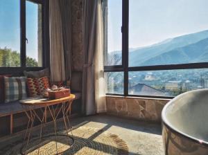 a living room with a large window with a view at Mogan Tingshan Hotel in Deqing