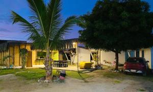 una casa con una palmera delante de ella en Pascana Casa Playa, en Máncora