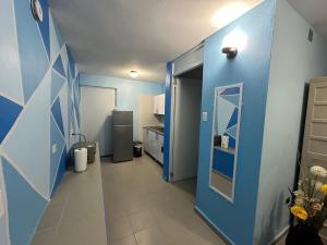 a blue room with a hallway with a refrigerator at Ocean View in Guayama