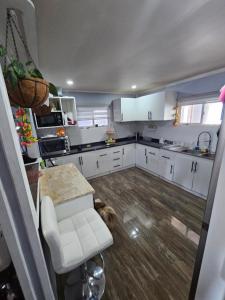 una cocina con armarios blancos y un perro tirado en el suelo en Casa 3 dormitorios, en Ancud