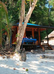 a person sitting at a table in front of a house at I&D Home Stay Raja Ampat in Yennanas Besir