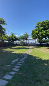 un chemin dans un parc avec un banc au loin dans l'établissement Paraíso tropical, à Cabo Frio