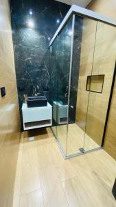 a bathroom with a glass shower and a sink at Espacio Verfemat in Posadas