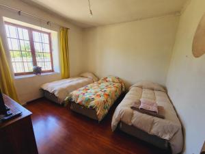 1 Schlafzimmer mit 2 Betten und einem Fenster in der Unterkunft Casa de Campo en Malloco in Peñaflor