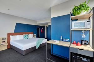 1 dormitorio con cama y pared azul en Together Co-Living Melbourne en Melbourne