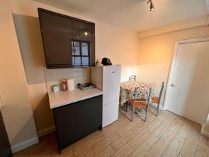 a small kitchen with a white refrigerator and a table at London Whitechapel Mile End in London