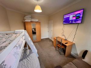 a bedroom with a bed and a desk and a tv at London Whitechapel Mile End in London