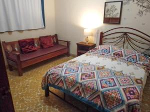 a bedroom with a bed and a couch at Los Nardos Hostel -pet friendly- in Oaxaca City