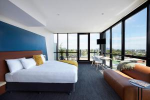 a hotel room with a bed and a couch at Together Co-Living Melbourne in Melbourne