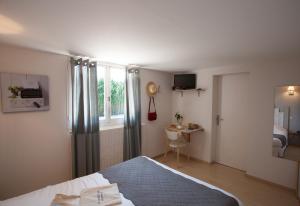 1 dormitorio con cama, ventana y escritorio en Hôtel La Ferme d'En Chon en Biscarrosse