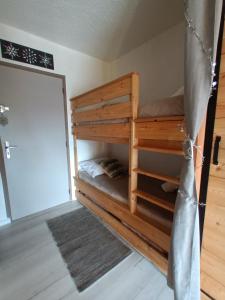 Etagenbett in einem Zimmer mit Tür in der Unterkunft Appartement montagne LE FLOCON in Saint-Michel-de-Chaillol + 42 Fotos