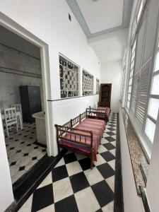 two beds in a room with a checkered floor at Casa de Maria Marta in Ilhéus