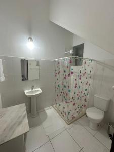 uma casa de banho com um chuveiro, um WC e um lavatório. em Casa de Maria Marta em Ilhéus